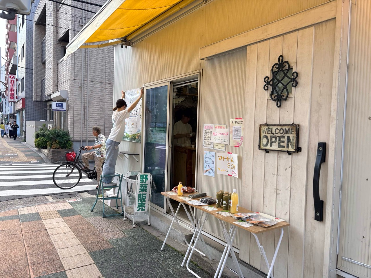 黄色いひさしと野菜販売台があるハッピーラボの店頭